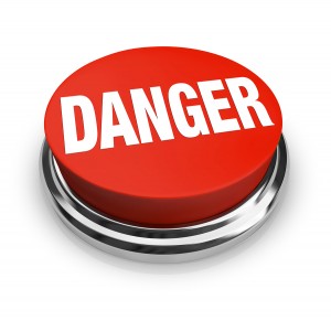A red button with the word Danger, illustrating the hazards and